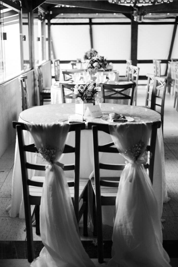 pexels photo 35143276 Black and white photo of an elegantly decorated wedding reception table with floral arrangements.